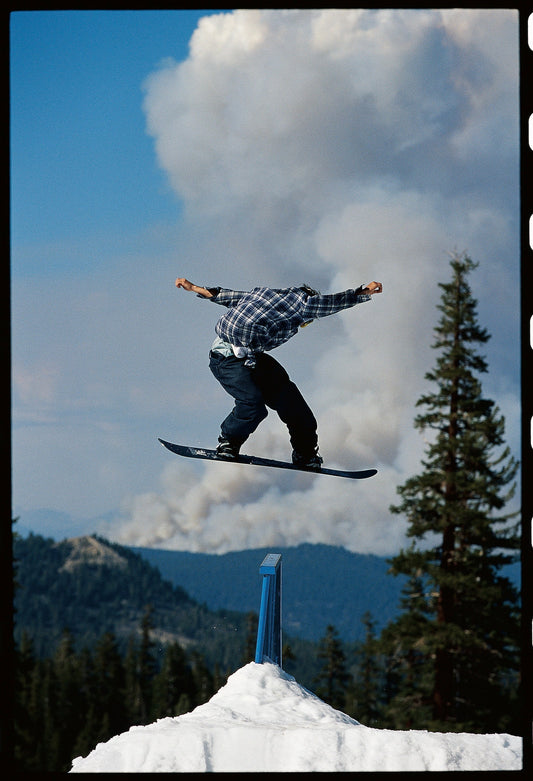 Snowboarder Jeff Anderson riding with forest fire in the background