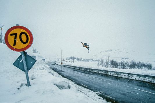Professional snowboarder Nicolas Müller jumping over the highway in Riksgränsen Sweden
