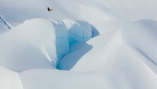 Snowboarder Torstein Horgmo jumps over a massive ice formation in Haines, Alaska