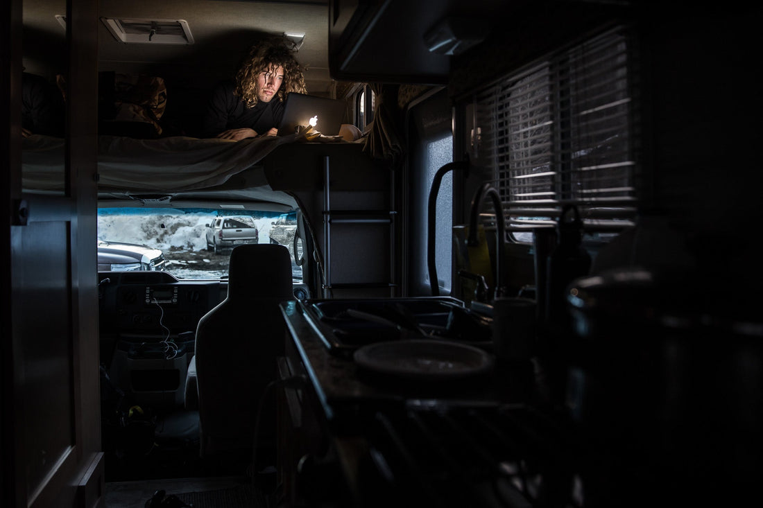 Snowboarder Rusty Ockenden waiting out bad weather days on his computer in the RV