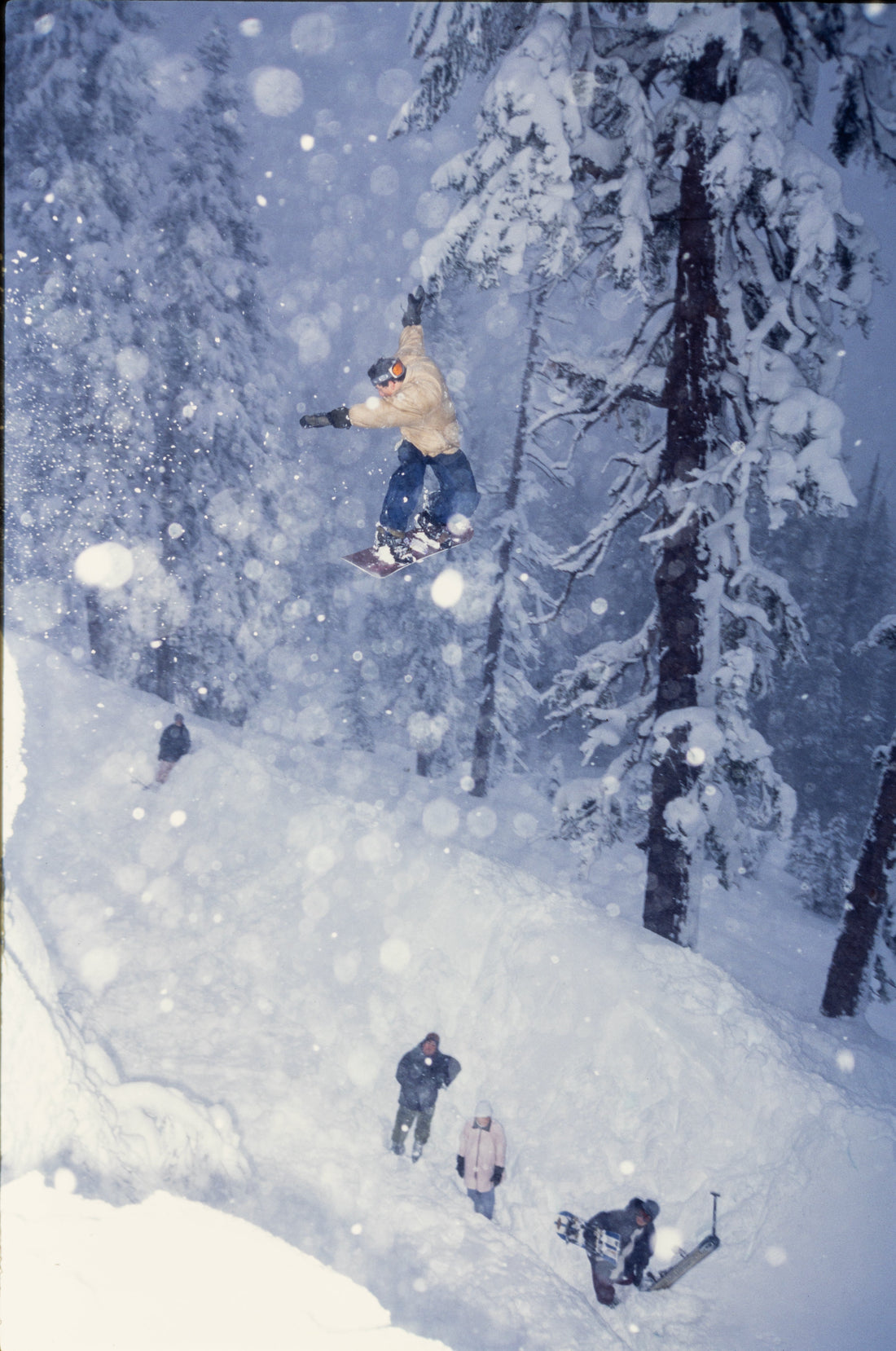 Snowboarder J2 switch backside 180 over Echo Summit, South Lake Tahoe